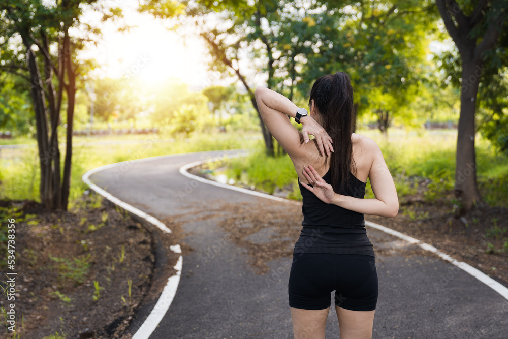 Asian woman in sports outfits doing stretching before workout outdoors in the park in the morning Asian woman in sports outfits doing stretching before workout outdoors in the park in the morning