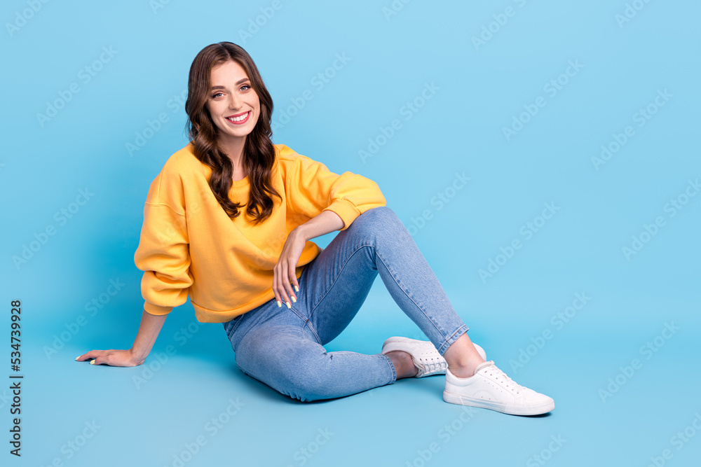 Full body photo of charming young lady sit floor relax clothes shopping promo wear trendy yellow garment isolated on blue color background