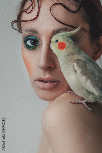 Tableau sur toile fashion portrait of a young woman with a cockatiel parrot