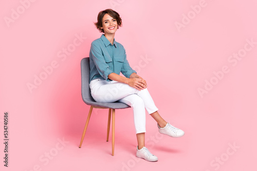 Photo of pretty positive lady office person sit chair relax wait coffee break leg crossed empty space isolated on pink color background © deagreez