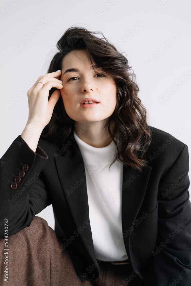 Attractive woman wear business look. Brunette model wear white shirt, black men's jacket and brown baggy pants. Winter, fall autumn or spring minimal outfit. Attractive woman wear business look. Brunette model wear white shirt, black men's jacket and brown baggy pants. Winter, fall autumn or spring minimal outfit.