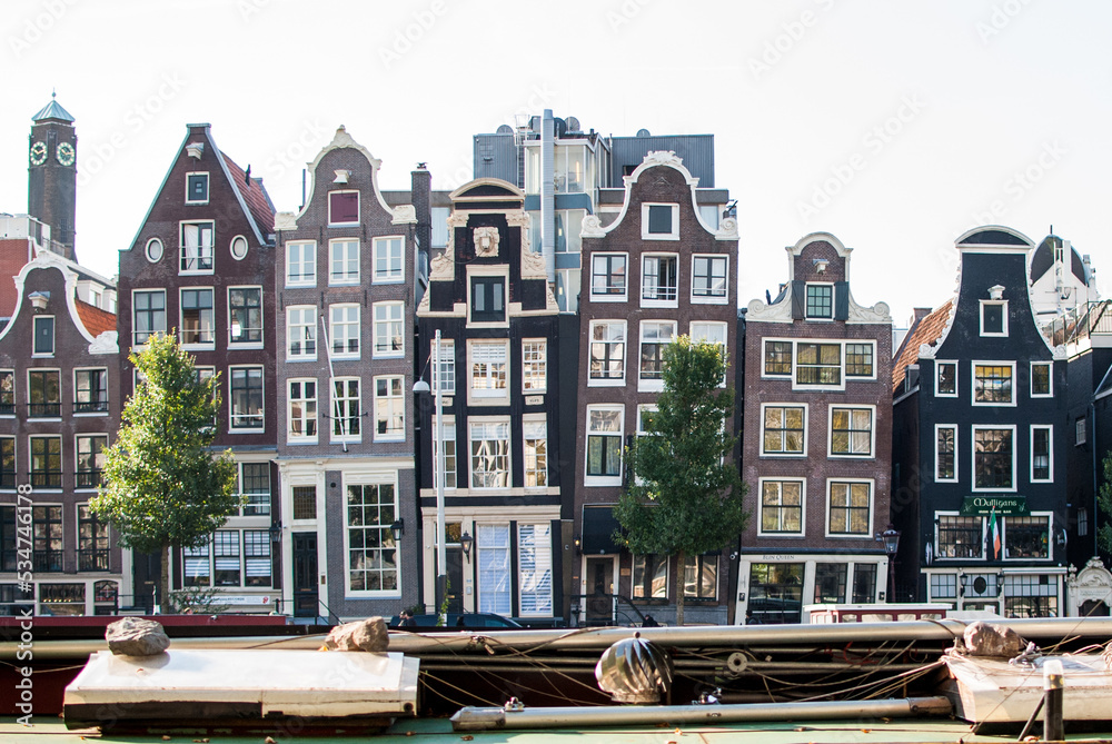 Edificios, juntos y estrechos de ladrillo, inclinados  con ventanas blancas   en amsterdam, países bajos, holanda
