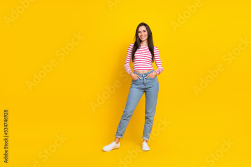 Full length photo of pretty lovely lady hand arm pocket wear striped outfit clothes stand empty space isolated on yellow color background