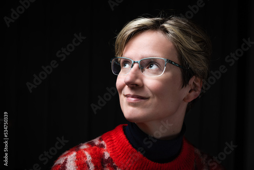Attractive thirty year old woman posing in the studio with a red pull over