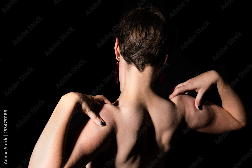 Thirty year old woman with naked torso, showing her muscles in a studio portrait Thirty year old woman with naked torso, showing her muscles in a studio portrait