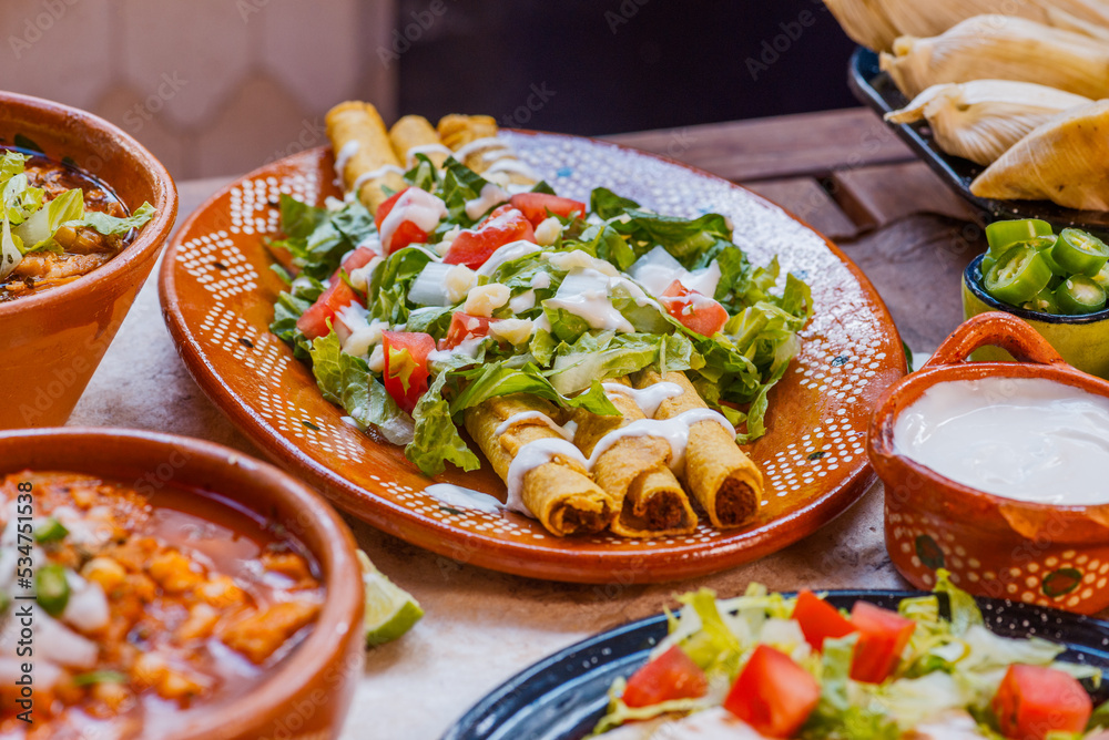 Flautas de maíz con ensalada de lechuga, tomate cebolla y bañadas de