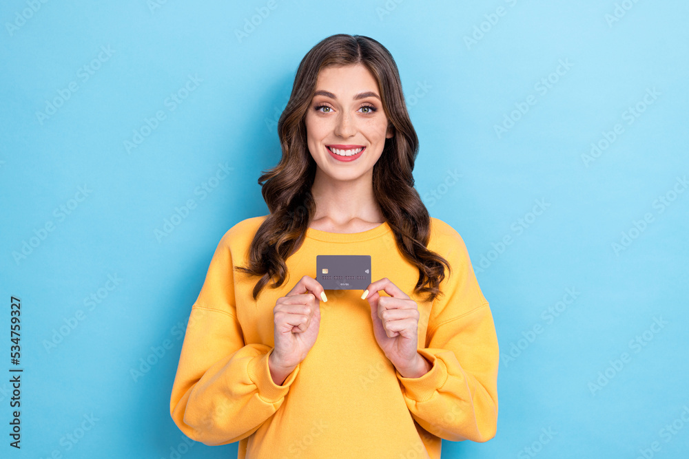 Photo of young adorable pretty nice woman wear yellow sweater hold credit card bank new user toothy smile positive good mood isolated on blue color background Photo of young adorable pretty nice woman wear yellow sweater hold credit card bank new user toothy smile positive good mood isolated on blue color background