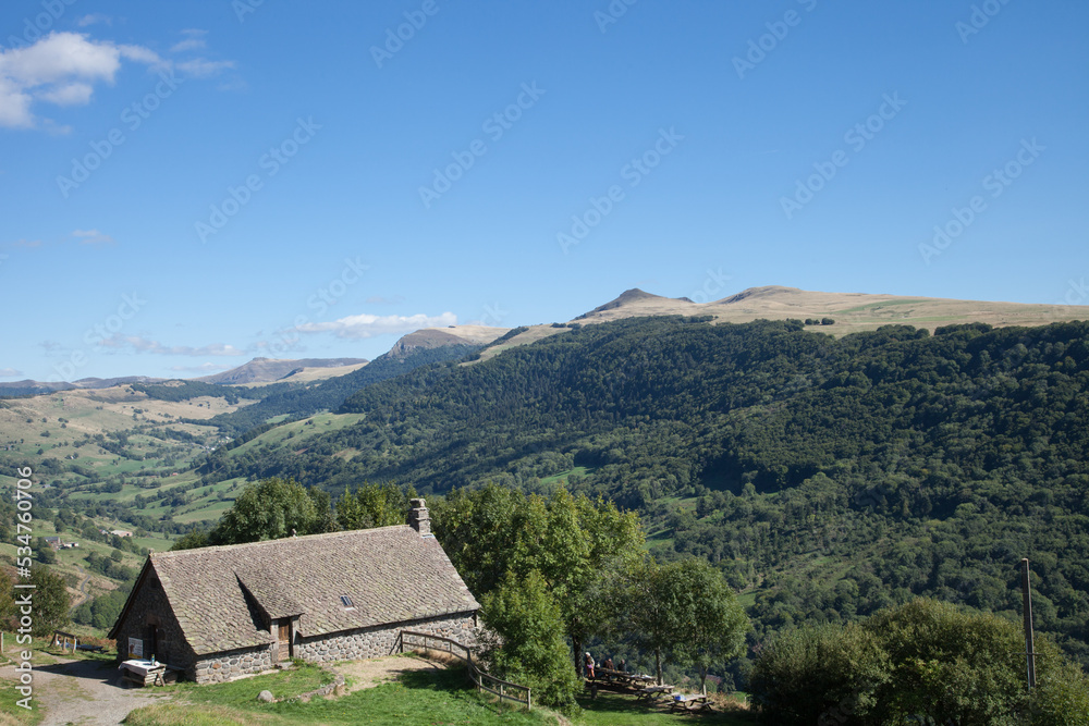 Maison au toit de lauzes face à la chaîne des Puys du Cantal