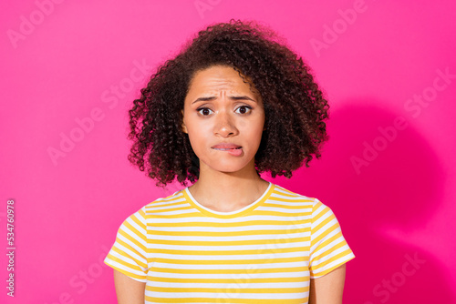 Close up photo of stunning young girl bite lip feel nervous unsure wear stylish striped garment isolated on vibrant pink color background © deagreez