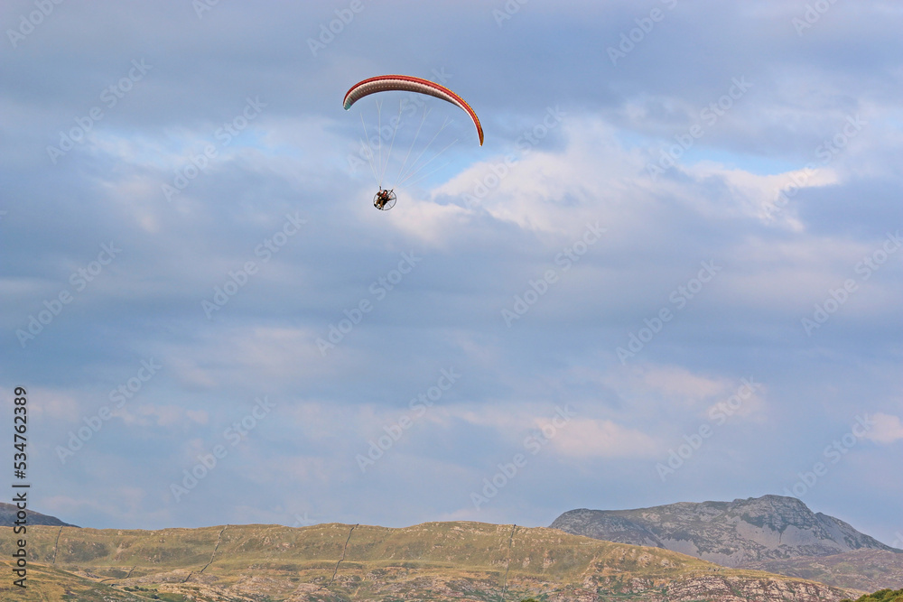 Paramotor pilot flying in the hills of Wales Paramotor pilot flying in the hills of Wales