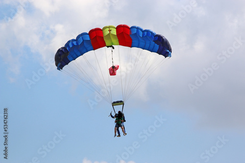 Tandem Skydiver flying wing in a blue sky	