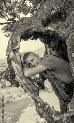 Portrait of man framed inside the roots of a tree trunk © jovannig