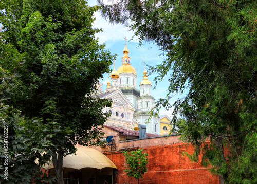 Pokrovskyi Monastery Cathedral is the oldest cathedral in Kharkiv, Ukraine, built in 1689. Ukrainian Baroque. Cultural and historical heritage of Ukraine. Temple view through a park tree branches