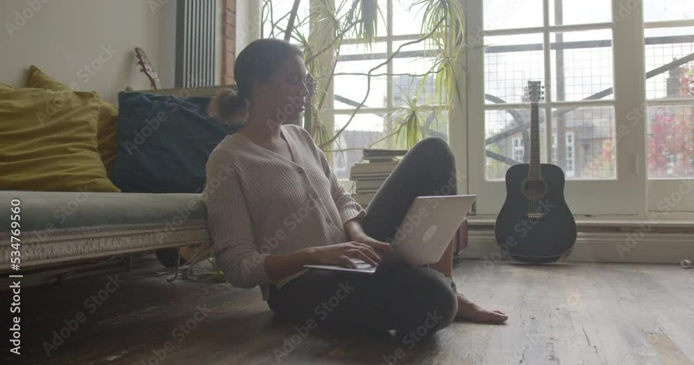 Young Adult Female Working from Home on Floor of Living Room Young Adult Female Working from Home on Floor of Living Room