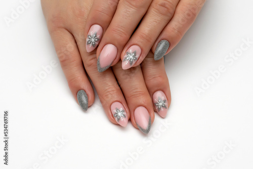 New Year s manicure with snowflakes. Silver manicure on long sharp nails dissolves on a white background.