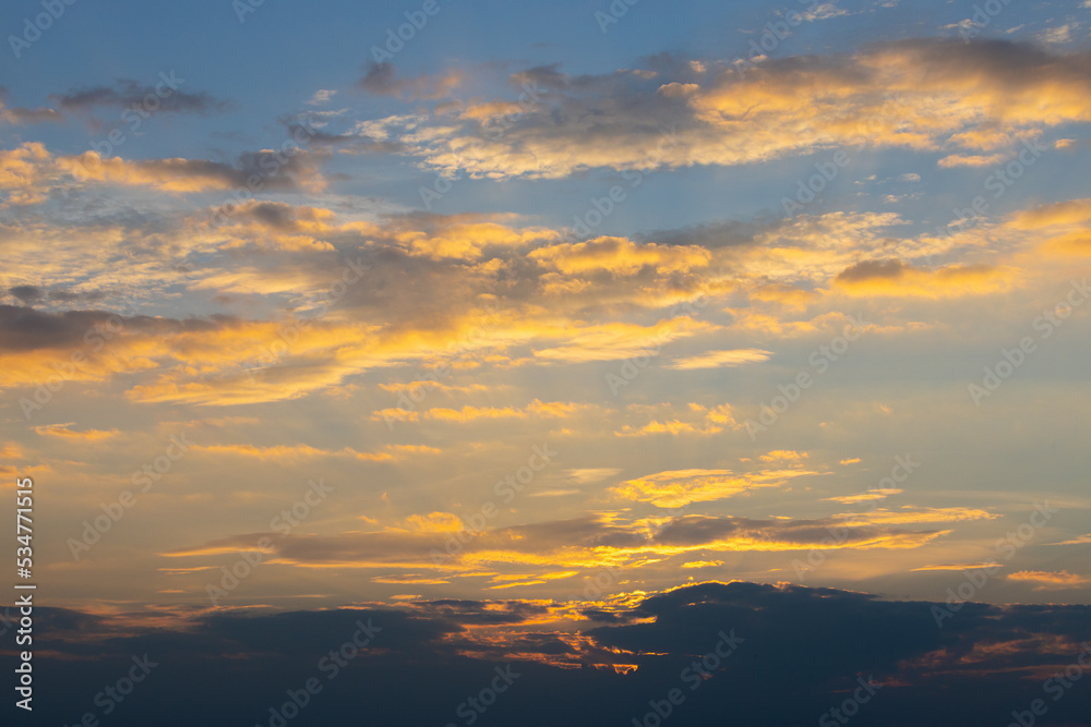 Golden clouds on blue sunset sky. Perfect evening sky background