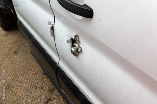 Broken vehicle door lock. Side panel cut with angle grinder.  White van damaged by a thief. Example of rural crime and vehicle crime in the UK.