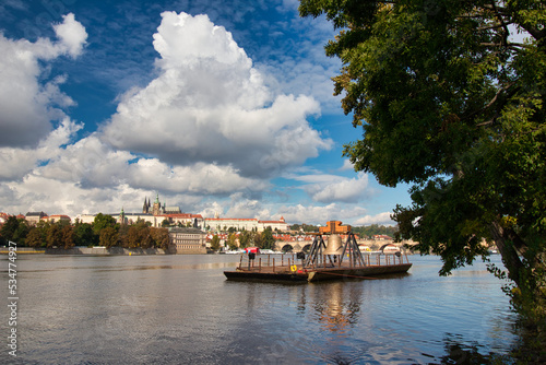 The Commemorative bell #9801 on a pontoon in the Vltava river at Smetanovo nábřeží. Prague. Prague Castle and Charles bridge in behind. photo