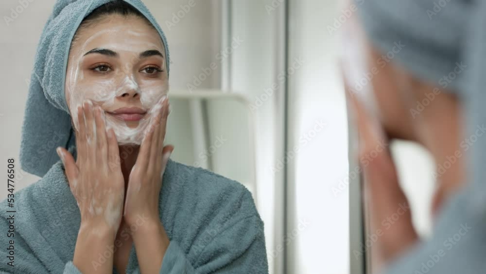 Reflection in a mirror beautiful woman washing her face
