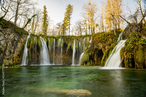 Plitvice Lakes National Park during colorful autumn, Croatia, Europe. Fall colors leafs on trees. Waterfalls and water in sunny morning light with fog. Landscape photography. View of Plitvicka Jezera. photo