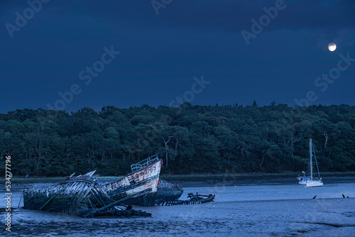 Rising moon over The Kerhervy boat graveyard in Lanester, Cimetière de bateaux, Finistère Brittany, épave bateau photo