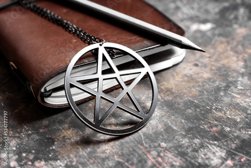 Leather spell book and pentagram on dark background