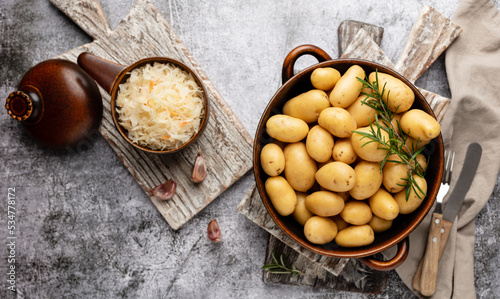 Raw small potatoes in a cast iron skillet on a beton background.