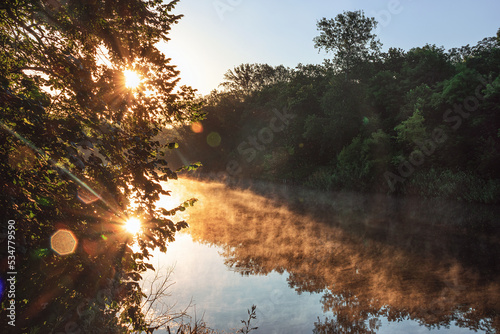 sunrise on the river in the forest with a light fog