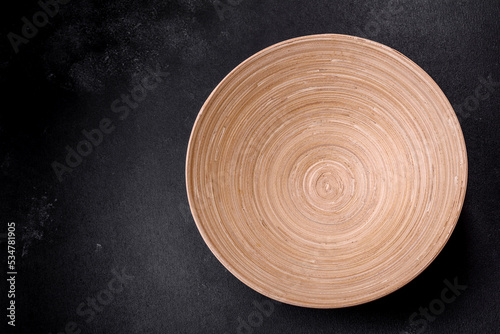 An empty wooden brown fruit bowl on a dark concrete background