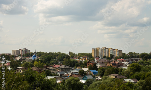 Panoramic top view of residential buildings among the lush green foliage of trees in Vladimir russia in the a cloudy summer day and a copy space