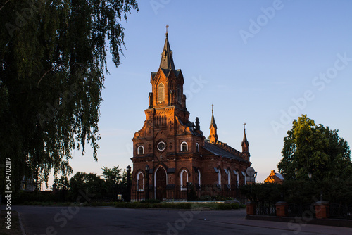 Vladimir, Russia, August, 17, 2022: Brick Catholic Church of the Holy Rosary of the Blessed Virgin Mary in the historical center on a sunny summer day among green trees