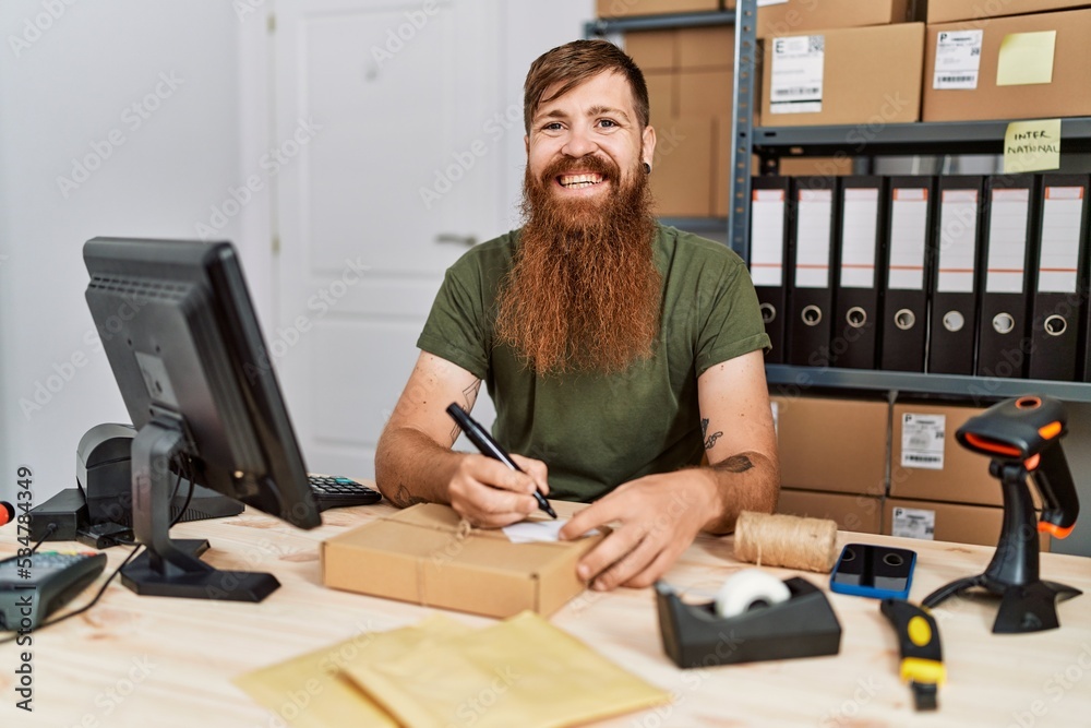 Young redhead man business worker prepare order package at office Young redhead man business worker prepare order package at office