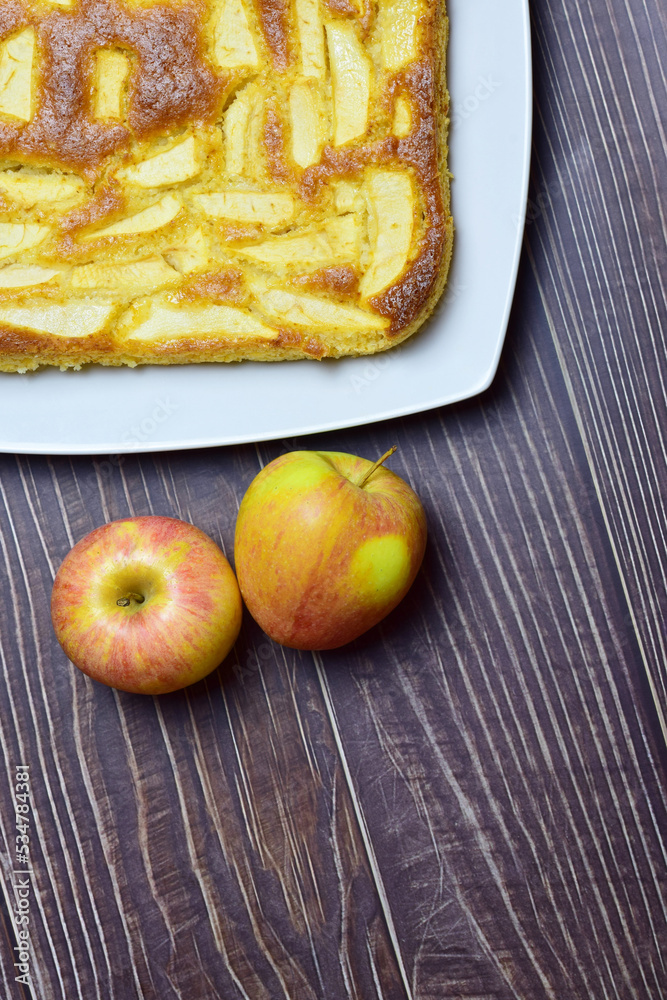 Homemade apple pie, white rectangular plate on brown rustic wood. Zenith view and copy space. Homemade apple pie, white rectangular plate on brown rustic wood. Zenith view and copy space.