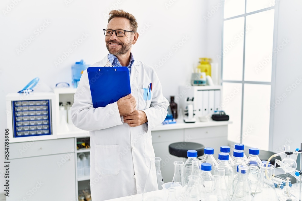 Middle age hispanic man smiling confident wearing scientist uniform at laboratory Middle age hispanic man smiling confident wearing scientist uniform at laboratory