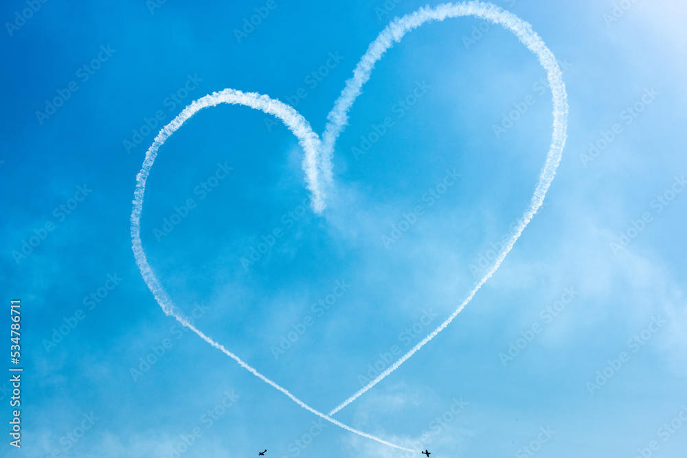 Two Light Airplanes In The Sky Writing Romantic Heart Shape - obrazy, fototapety, plakaty 