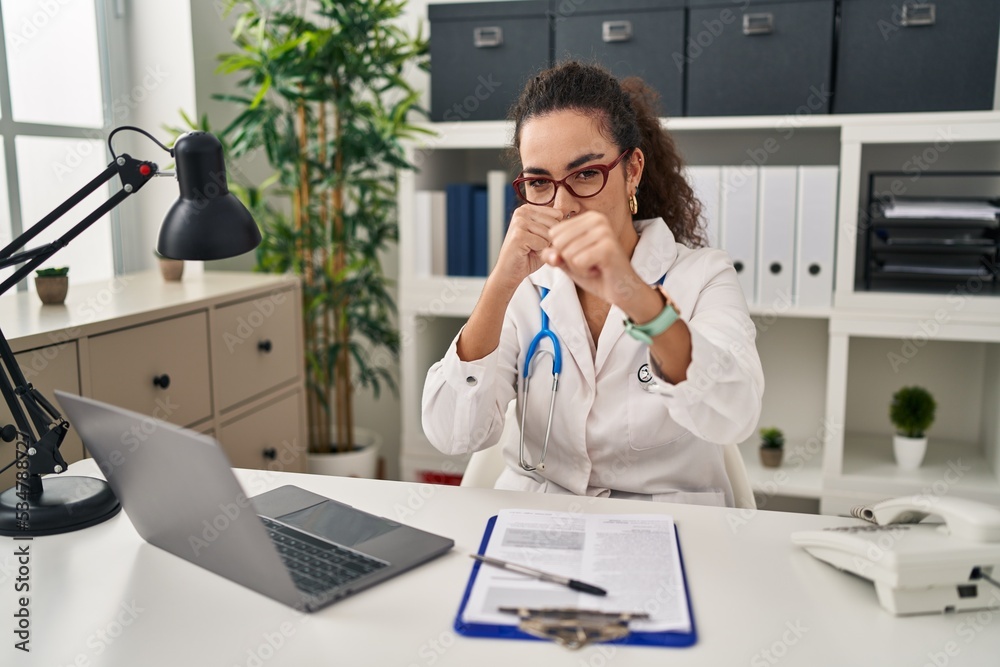 Young hispanic woman wearing doctor uniform and stethoscope ready to fight with fist defense gesture, angry and upset face, afraid of problem Young hispanic woman wearing doctor uniform and stethoscope ready to fight with fist defense gesture, angry and upset face, afraid of problem