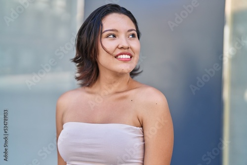 Free Download Young hispanic woman smiling confident looking to the side at street - GFXLoad