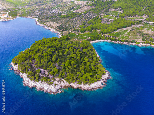 aerial view of a wonderful Mediterranean bay on the peljesac peninsula; paradise beach with turquoise water and rocky coastline with mighty mountains in the background; trstenik in croatia