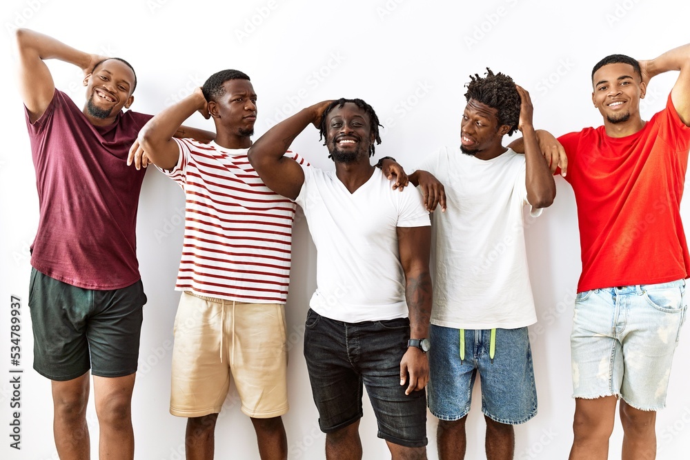 Obraz premium Young african group of friends standing together over isolated background smiling confident touching hair with hand up gesture, posing attractive and fashionable