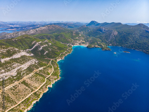 aerial view of the peljesac peninsula in croatia; paradise beaches with turquoise water and rocky coastline; mighty mountains over the mediterranean sea; peljesac bridge; croatian adriatic coastline