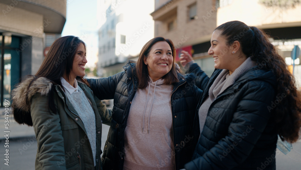 Mother and daugthers smiling confident hugging each other at street Mother and daugthers smiling confident hugging each other at street