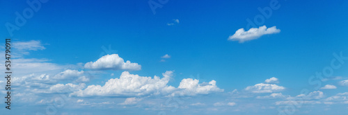 White small curly clouds in the blue sky in sunny weather