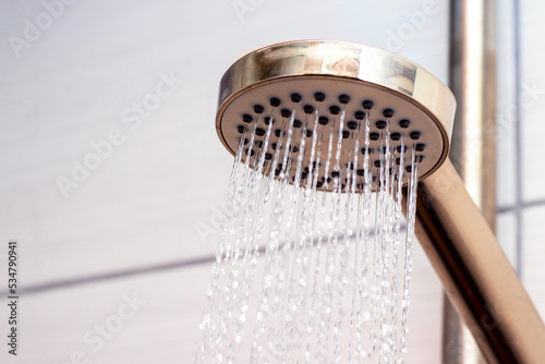 The flow of water from the watering can in the shower, close-up. Taking a shower