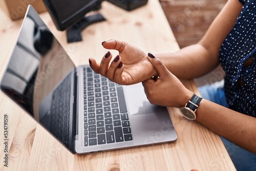 African american woman ecommerce business worker suffering for hand injury at office