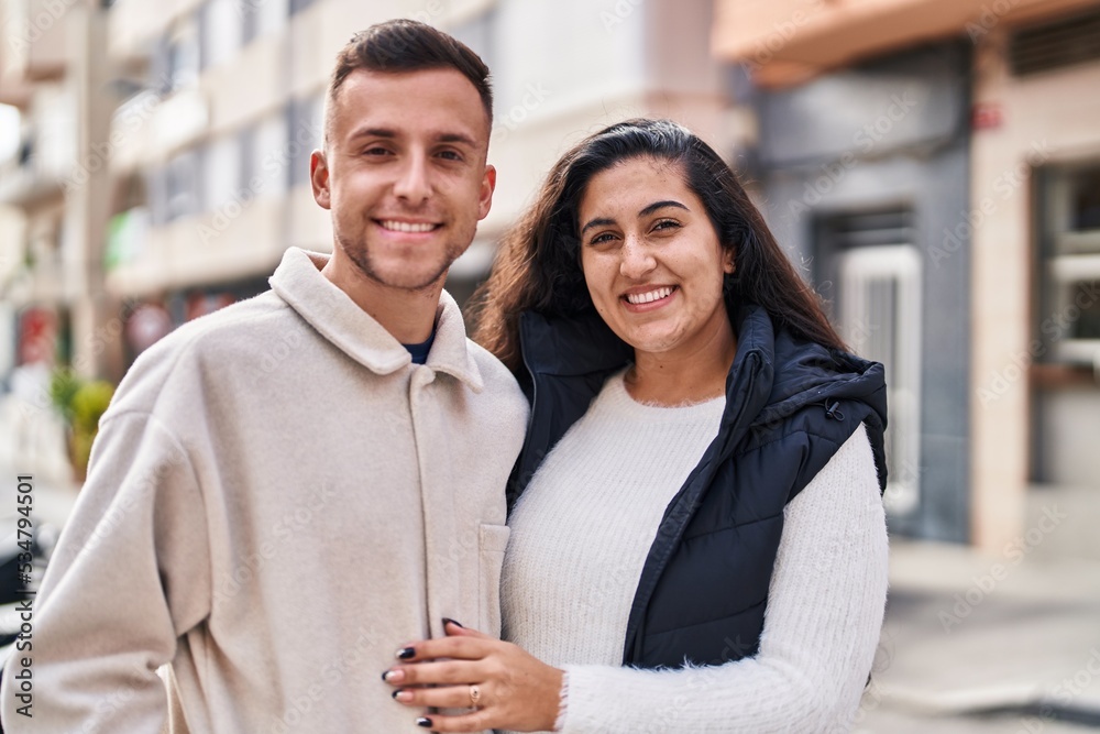 Man and woman couple hugging each other standing at street Man and woman couple hugging each other standing at street