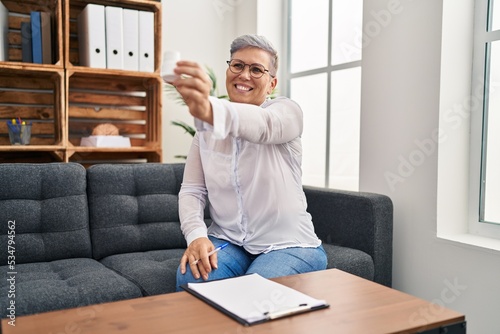 Middle age woman psychologist prescribe pills at pyschology center photo