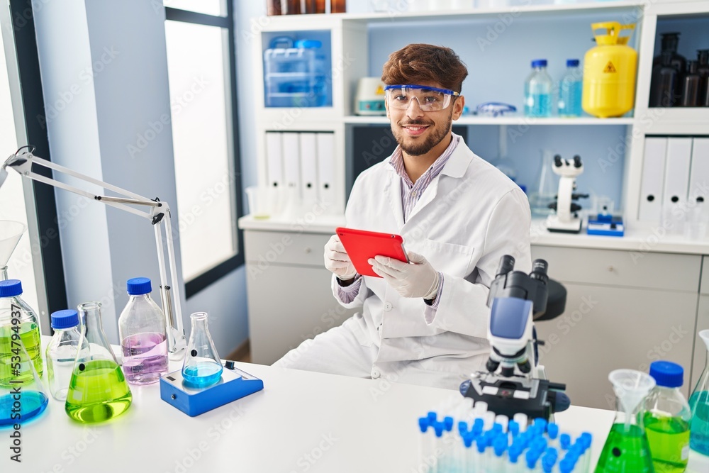 Young arab man scientist using touchpad working at laboratory Young arab man scientist using touchpad working at laboratory