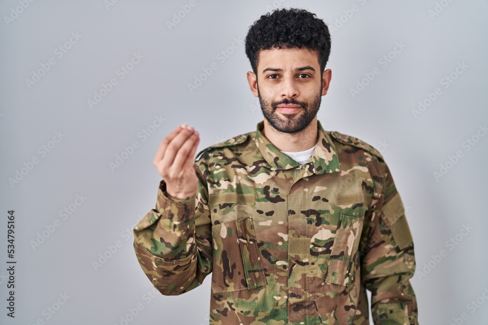 Arab man wearing camouflage army uniform doing italian gesture with hand and fingers confident expression Arab man wearing camouflage army uniform doing italian gesture with hand and fingers confident expression
