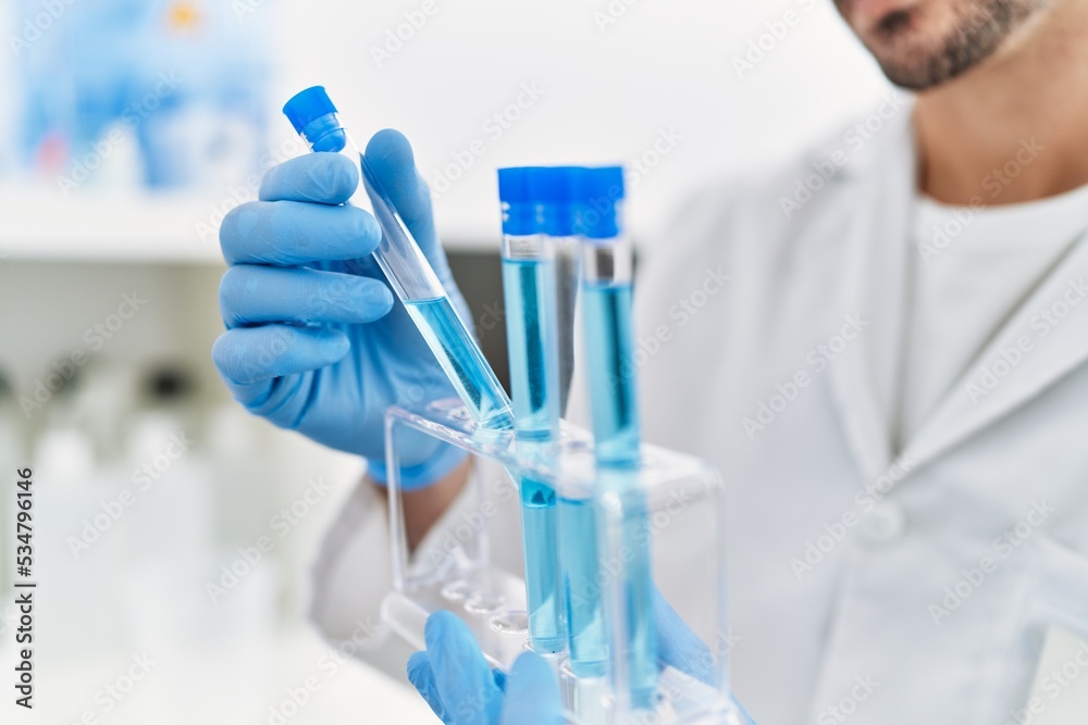 Handsome hispanic man working as scientific holding test tubes at laboratory Handsome hispanic man working as scientific holding test tubes at laboratory