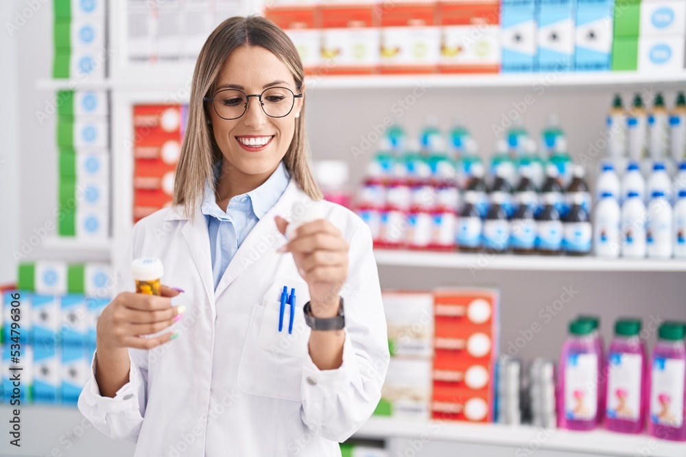 Young beautiful hispanic woman pharmacist smiling confident holding pills bottles at pharmacy Young beautiful hispanic woman pharmacist smiling confident holding pills bottles at pharmacy